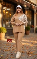 ست بافت زنانه کرم با طرح گلدار روی پلیور، ست شده با شلوار بافت و بوت روشن در استایل پاییزی