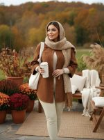 مانتو پاییزه گلاره قهوه‌ای روی ست کرم با شال و شال‌گردن بافتنی، استایل گرم و پاییزی در فضای باز